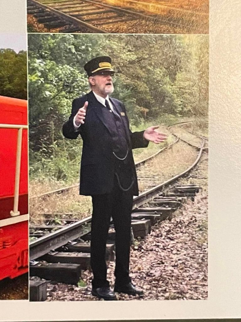 Author W. Keith Brenton, standing by the rails of the ESNA at Junction, Arkansas; telling unseen passengers a story, using his hands to illustrate.